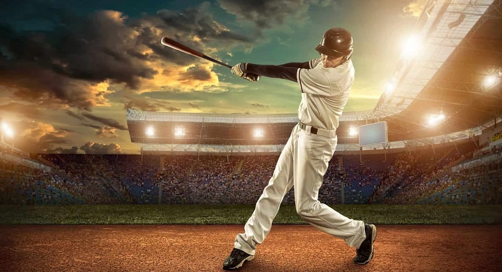 A baseball player mid-pitch on the mound, wearing a black baseball cap paired with a blue and black jersey, white pants, and cleats. The cap complements the player's athletic look while providing functional sun protection, highlighting its dual role as a style and performance essential for 2025. Best Baseball Caps for Men: Choosing the Right One