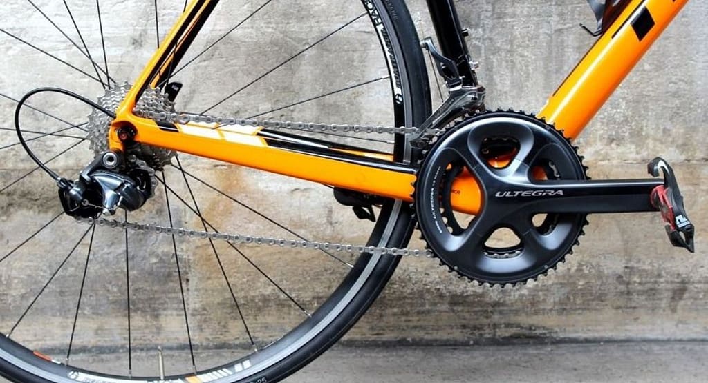 "Close-up of an old bicycle gear shifting mechanism, showcasing the chain, crankset, and derailleur components. A simple guide to mastering your bike’s gears can help optimize shifting performance for smoother rides." Old Bike Gear System