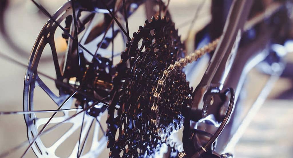 "Close-up of an old bicycle gear shifting mechanism, showcasing the chain, crankset, and derailleur components. A simple guide to mastering your bike’s gears can help optimize shifting performance for smoother rides." the Proper Way to Shift Gears on a Bicycle