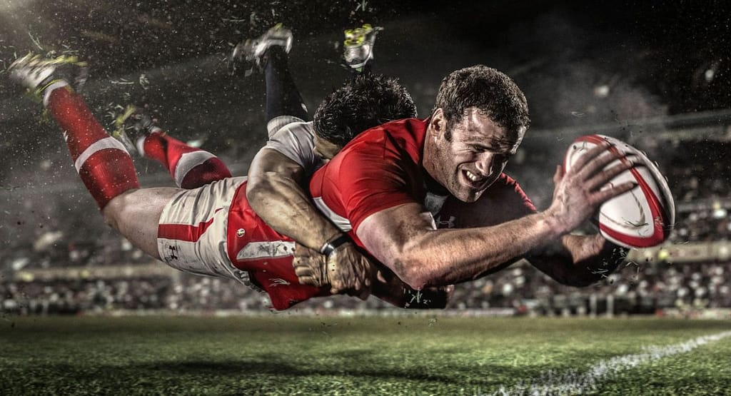 "Four male rugby players wearing professional rugby uniforms, including Akuma high-performance rugby shorts, standing confidently in a studio setting. The players are dressed in matching blue and red kits branded with 'RaboDirect' and 'BLK,' showcasing athletic fit, modern design, and functional sportswear tailored for competitive performance."