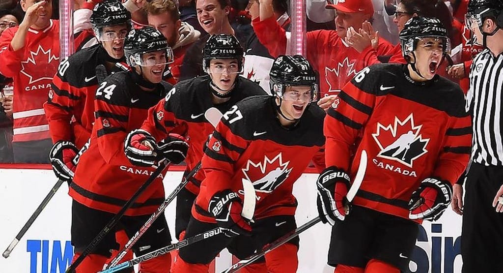 Action shot from a professional ice hockey game showing players in motion. While the image features teams in black and white/red jerseys, it does not depict the classic Chiefs hockey jersey made famous by the fictional Charlestown Chiefs from Slap Shot. The Chiefs jersey typically features blue and gold striping with bold "Chiefs" lettering across the chest