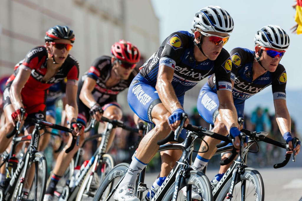 write for us + sports Competitive cyclists in a high-speed race, showcasing athleticism and teamwork.