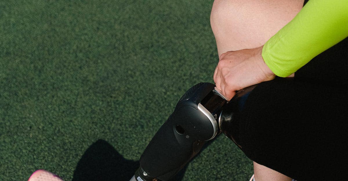 blog Close-up of athlete wearing prosthetic leg and pink sports shoes on a field.