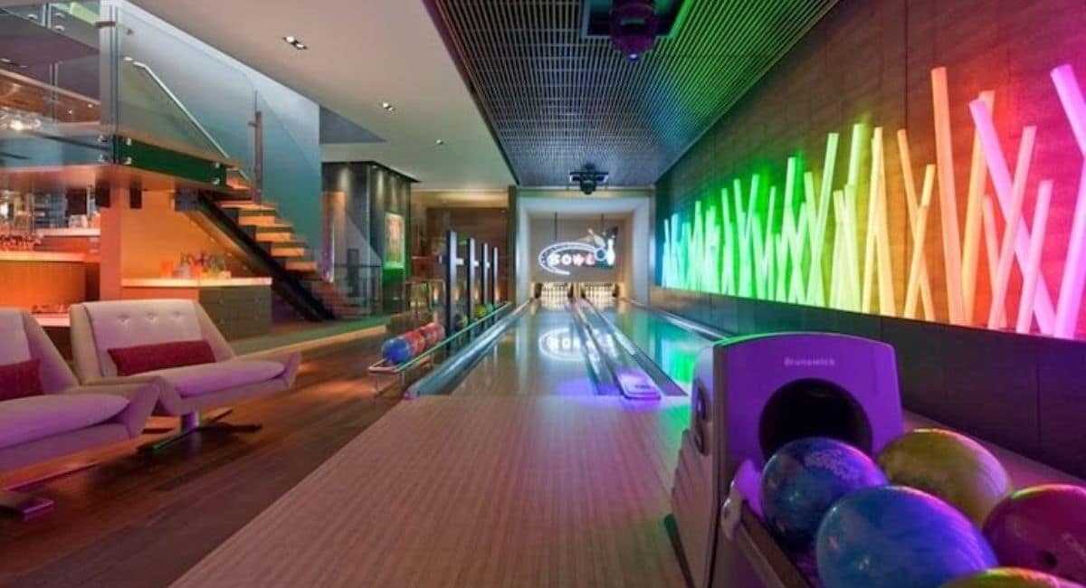 “Bowling Alley Glow in the Dark: Your Ultimate Guide a modern glow-in-the-dark bowling alley with vibrant neon wall lights, colorful bowling balls on a sleek wooden lane, and contemporary lounge seating under a futuristic ceiling.”
